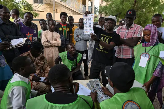 Des scrutateurs tiennent des bulletins de vote pendant le dépouillement de l'élection présidentielle tchadienne dans un bureau de vote à N'Djamena le 6 mai 2024.