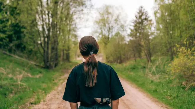 Орқасини ўгириб суратга тушган ўсмир қиз. 