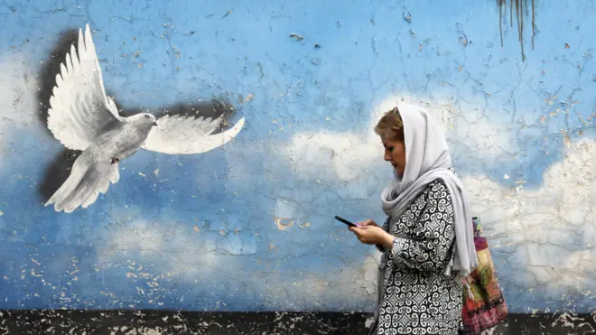 امرأة إيرانية تمرّ بجانب لوحة جدارية لطائر السلام في أحد شوارع وسط طهران، إيران، 1 أغسطس/آب 2022. ووفقاً لوزارة الخارجية الإيرانية، يُرجّح عقد جولة جديدة من المحادثات النووية في فيينا قريباً، بعد ردود على مقترح قدّمه كبير دبلوماسيي الاتحاد الأوروبي جوزيب بوريل يهدف إلى إنقاذ الاتفاق النووي المبرم عام 2015 مع القوى العالمية. وتواجه إيران أزمة اقتصادية في أعقاب العقوبات التي فرضتها الولايات المتحدة وقوى دولية أخرى بسبب برنامجها النووي.