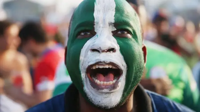 Un homme avec un drapeau nigérian peint sur le visage