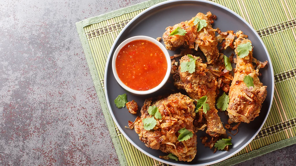 A bottle of soy sauce is poured over a bowl of rice. (Credit: Getty Images)