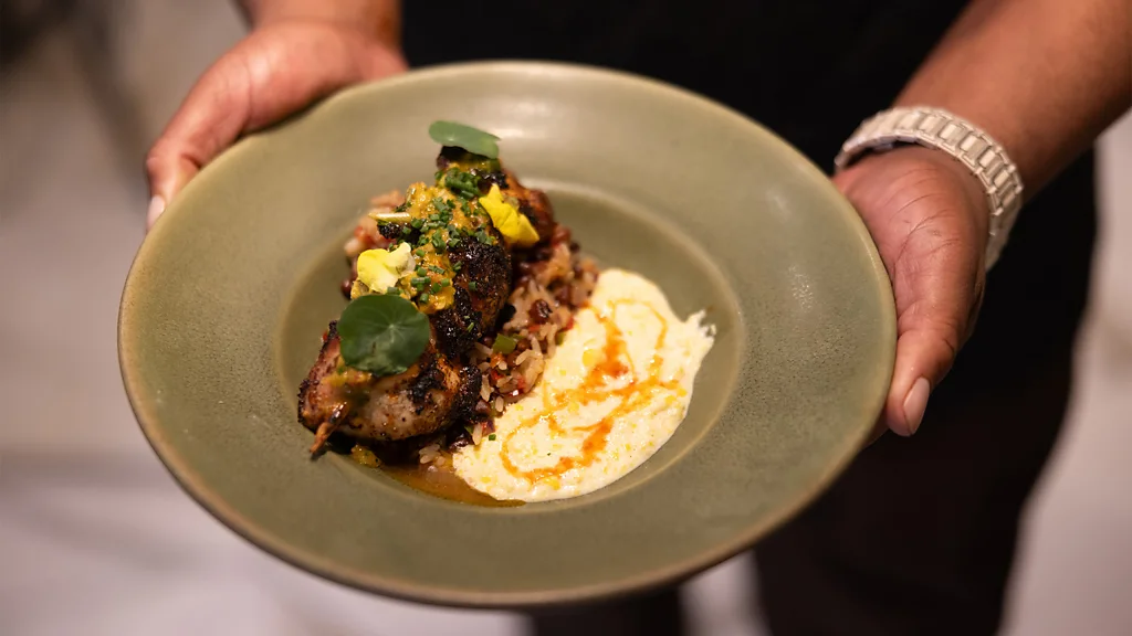 A chef presents a modern soul food dish, fumeé sumac chicken, at Auburn Angel restaurant in Atlanta, Georgia (Credit: Lynsey Weatherspoon)