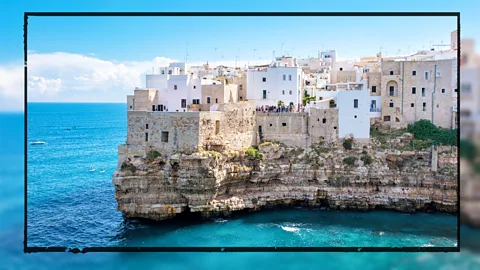 Buildings in Puglia, Italy, are shown on a cliff overlooking the Mediterranean Sea (Credit: Alamy)