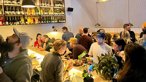 People eating and drinking at a bar in East London (Credit: Stephen Emms)