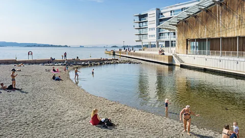 People on small beach in Aker Brygge district in downtown Oslo Norway (Credit: Alamy)
