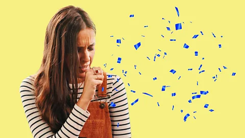 Artwork of woman coughing with blue particulates flying around against a yellow background (Credit: Yun Sun Park/ BBC)