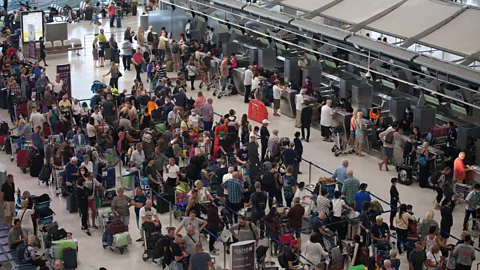 A crowded check-in line at an airport (Credit: Getty Images)