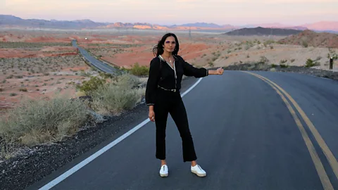 Padma Lakshmi stands on an open road with the sunset behind her (Credit: Courtesy of Padma Lakshmi)