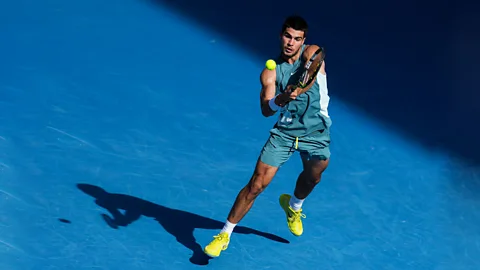 Getty Images Carlos Alcaraz jumps to return a ball with his tennis racket (Credit: Getty Images)
