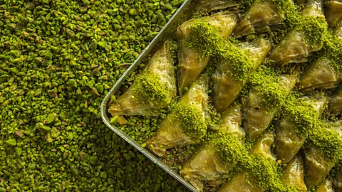 Getty Images A tray of pistachio baklava over a bed of pistachios (Credit: Getty Images)