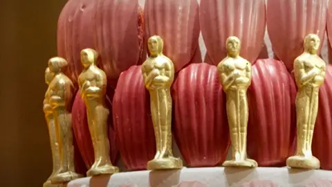 A cake decorated with edible gold Oscar statuettes