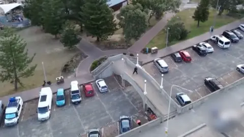An aerial view of a bridge over a carpark