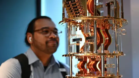 Getty Images A bystander looks at the gold electronics of an IBM quantum computer