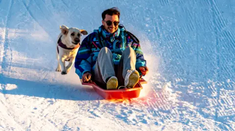 Luca Carano Luca Carano sledging down a snowy hill with his dog 