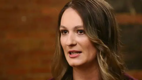 CBS Evening News Annika Albrecht speaks in a brown shirt