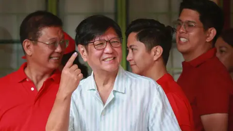 Philippine President Ferdinand Marcos shows his inked finger after voting in the mid-term election at a polling station in Batac town, Ilocos Norte province on May 12, 2025.