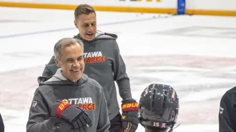 Alexander Stubb and Mark Carney are seen playing hockey.