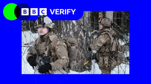 UK troops on Nato cold weather exercises in Estonia. Two soldiers can be seen in the snow, wearing camouflage gear and helmets and holding rifles. The BBC Verify logo is overlaid on top.